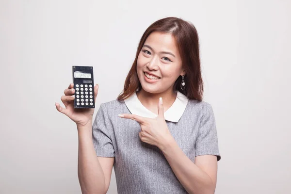 Азиатка указывает на калькулятор . — стоковое фото