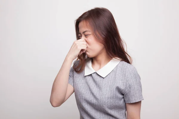 Ung asiatisk kvinna hålla hennes näsa på grund av dålig lukt. — Stockfoto