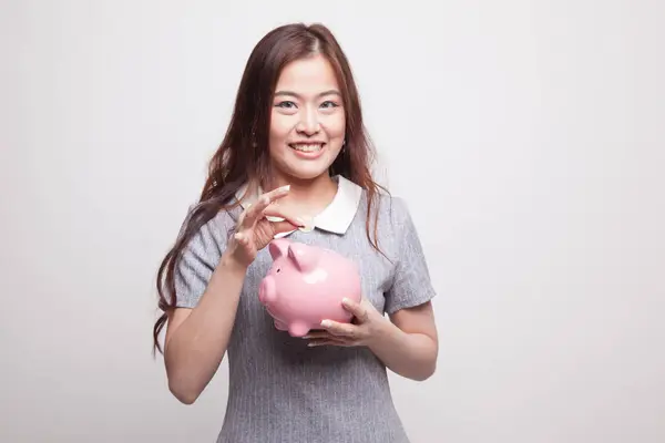 Asijské žena s mincí a prasátko kasička. — Stock fotografie