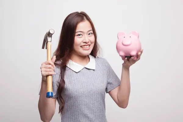 Asian woman with pig coin bank and hammer. — Stock Photo, Image