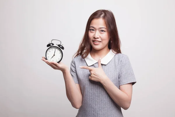 Young Asian woman point to a clock. — Stock Photo, Image