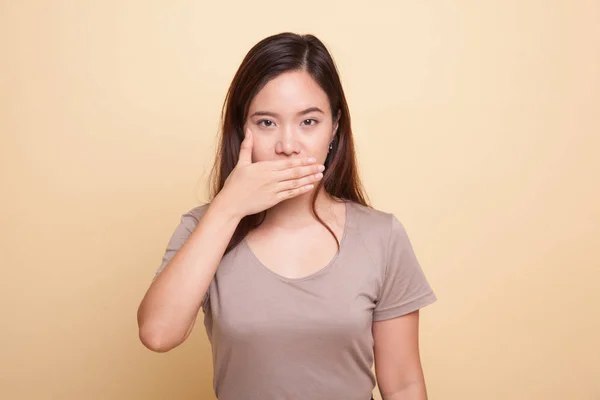 Jonge Aziatische vrouw haar mond met de hand dicht. — Stockfoto