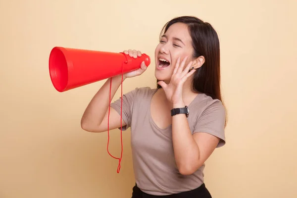 Mooie jonge Aziatische vrouw kondigen met megafoon. — Stockfoto