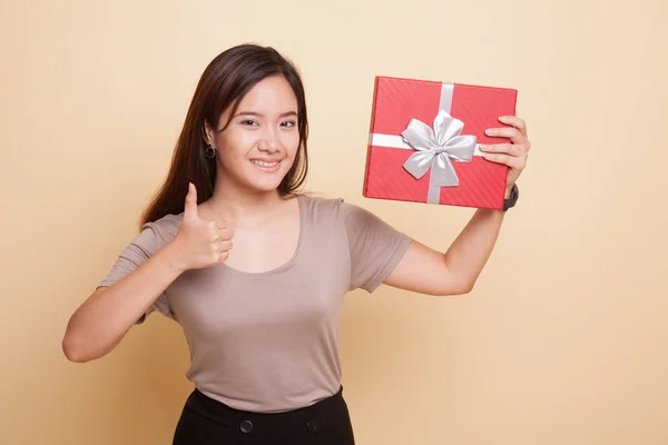 Young Asian woman thumbs up with a gift box. — Stock Photo, Image