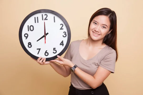 Young Asian woman with a clock. — Stock Photo, Image