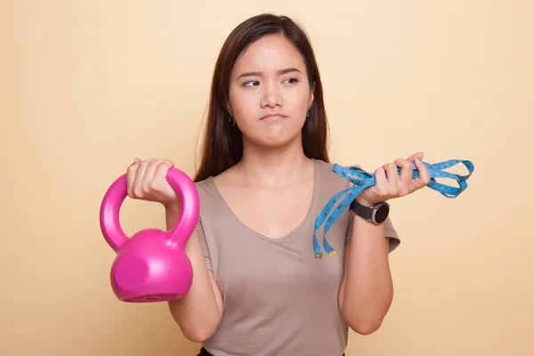 Esausto asiatico donna con kettlebell e metro nastro . — Foto Stock