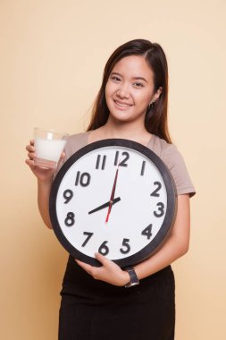 Sağlıklı Asyalı kadın süt içme cam saat tutun.