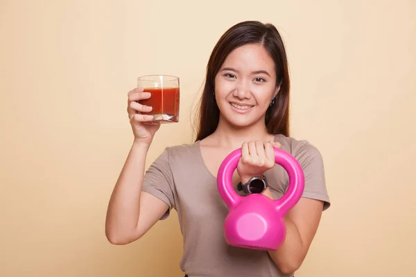 Saludable mujer asiática con kettlebell y jugo de tomate . — Foto de Stock