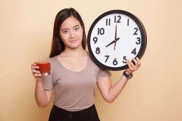 年轻的亚裔女子和番茄汁和时钟. — 图库照片