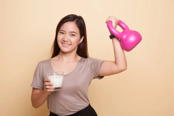 Saludable mujer asiática bebiendo un vaso de leche y kettlebell —  Fotos de Stock