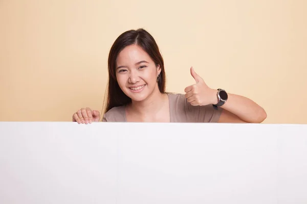 Ung asiatisk kvinna visar tummen upp med tomma tecken. — Stockfoto