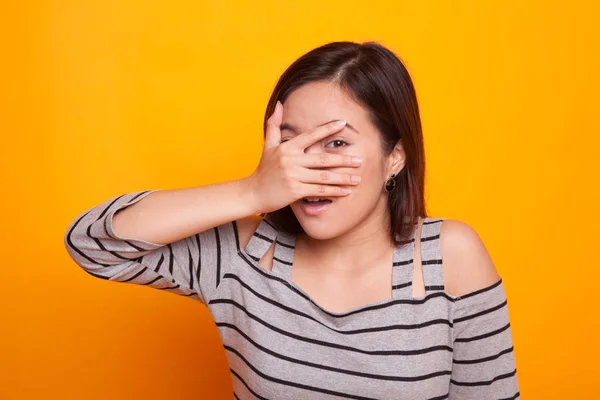 Vacker ung asiatisk kvinna kikar genom fingrarna. — Stockfoto