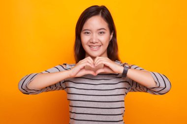 Genç Asyalı kadın kalp işaret göster.