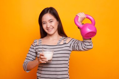 Bir bardak süt ve halter içme sağlıklı Asyalı kadın.