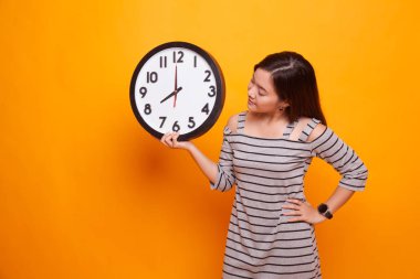 Saati olan genç Asyalı kadın..