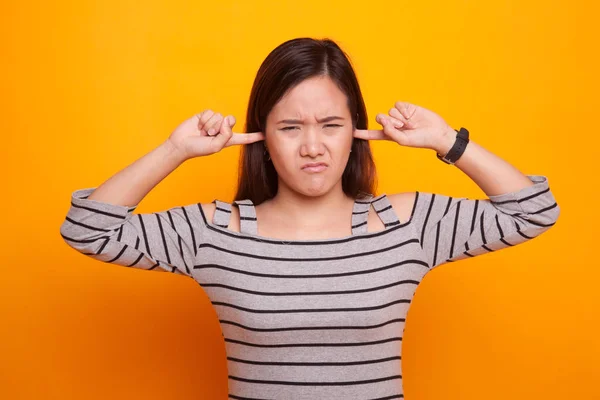 Young Asian woman block both ears with fingers. — Stock Photo, Image