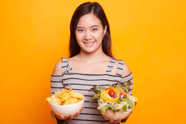 Ung asiatisk kvinna med potatischips och sallad. — Stockfoto