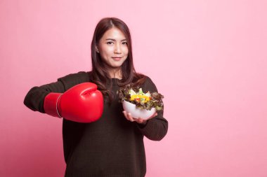 Genç Asyalı kadın boks eldiven ve salata ile.