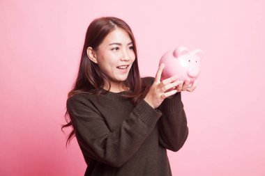 Bir domuz para banka ile genç Asyalı kadın.