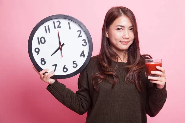 Young Asian woman with tomato juice and clock. — Stock Photo, Image