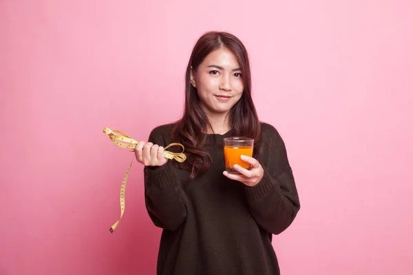 Asiatico donna bere arancia succo tenere misurazione nastro . — Foto Stock