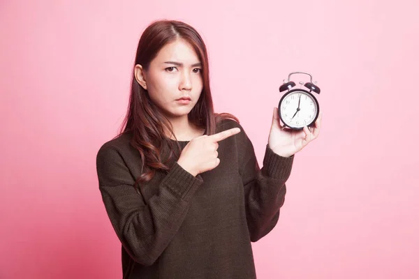 Wütende junge asiatische Frau zeigt auf eine Uhr. — Stockfoto