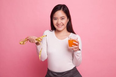 Asyalı kadın içki portakal suyu tutun teyp ölçme.