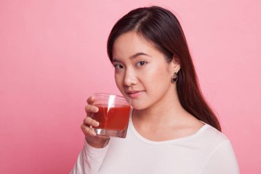 Genç Asyalı kadın içki domates suyu.