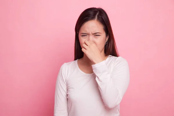 Junge asiatische Frau hält ihre Nase wegen eines schlechten Geruchs. — Stockfoto