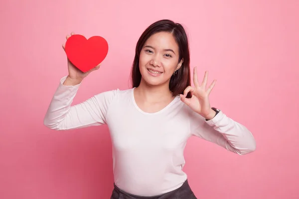 Pokaż Asian kobieta Ok z czerwonym sercem. — Zdjęcie stockowe