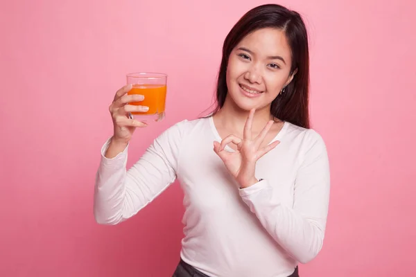 Jonge Aziatische vrouw Toon Ok drinken sinaasappelsap. — Stockfoto