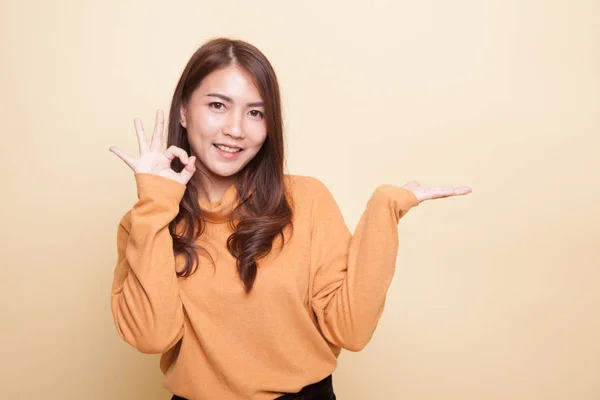 Beautiful young Asian woman show palm hand and OK sign. — Stock Photo, Image