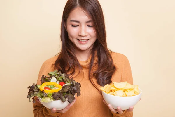 Jonge Aziatische vrouw met aardappel frites en salade. — Stockfoto