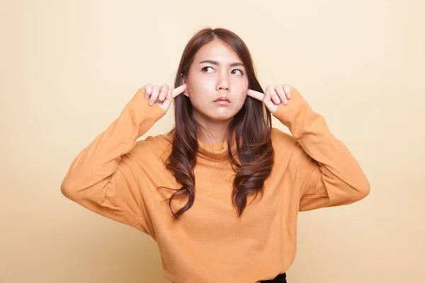 Young Asian woman block both ears with fingers. — Stock Photo, Image
