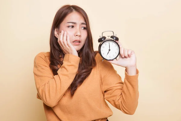 Jonge Aziatische vrouw wordt benadrukt met een klok. — Stockfoto