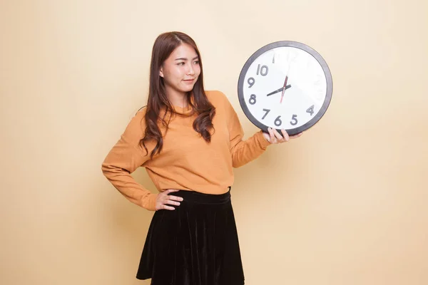 Young Asian woman with a clock. — Stock Photo, Image