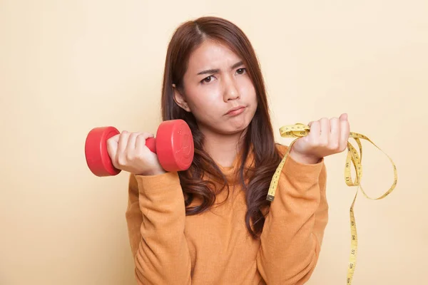 Esausta donna asiatica con manubri e nastro di misurazione . — Foto Stock