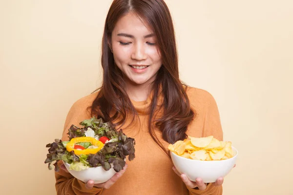 Ung asiatisk kvinna med potatischips och sallad. — Stockfoto