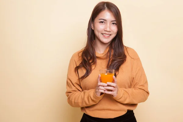 Jovem mulher asiática beber suco de laranja . — Fotografia de Stock