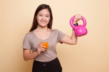 Kettlebell içki portakal suyu ile genç Asyalı kadın.