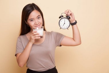Sağlıklı Asyalı kadın süt içme cam saat tutun.
