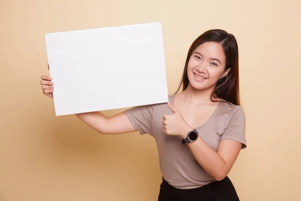 年轻的亚裔女子拇指拿着白色的空白符号. — 图库照片