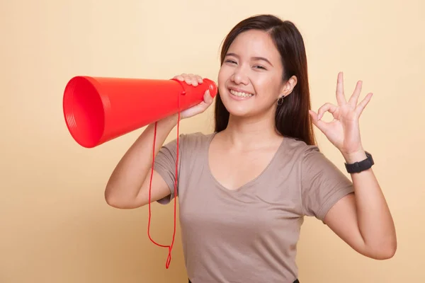 Mooie jonge Aziatische vrouw Toon Ok kondigen met megafoon. — Stockfoto