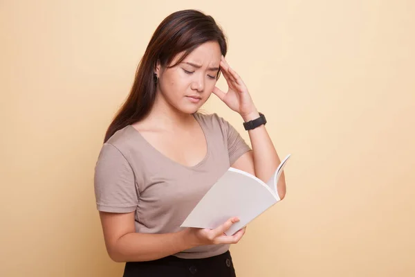 Giovane donna asiatica ha avuto mal di testa leggere un libro . — Foto Stock