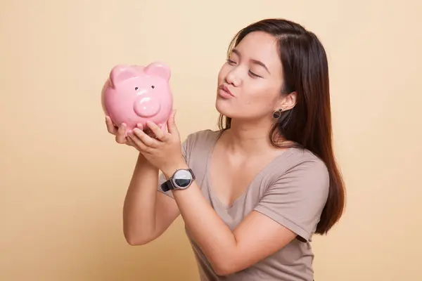 Mladá asijská žena kiss růžová mince banka. — Stock fotografie