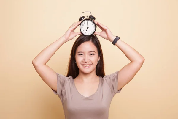 Jeune femme asiatique sourire avec une horloge . — Photo