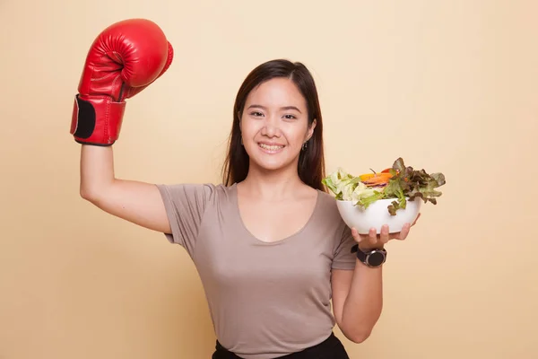 Giovane donna asiatica con guanto da boxe e insalata . — Foto Stock