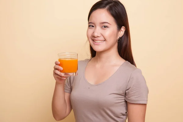 Jonge Aziatische vrouw drankje oranje sap. — Stockfoto