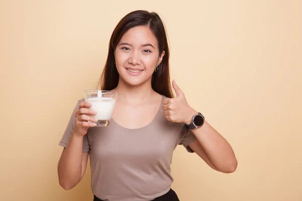 Saludable mujer asiática bebiendo un vaso de leche pulgares arriba . — Foto de Stock