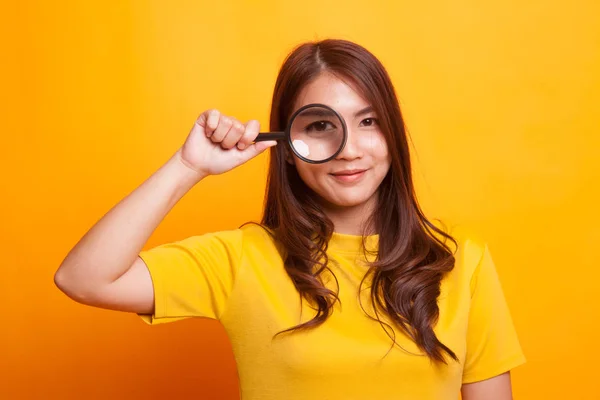 Ung asiatisk kvinna med förstoringsglas. — Stockfoto